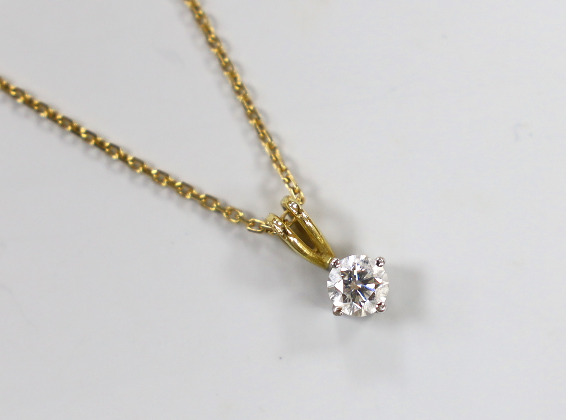 A modern 18ct gold and solitaire diamond set pendant, 10mm, on an 18ct gold chain, 40cm, gross weight 2.8 grams.